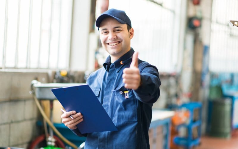 Assembly worker smiles and gives a thumbs up