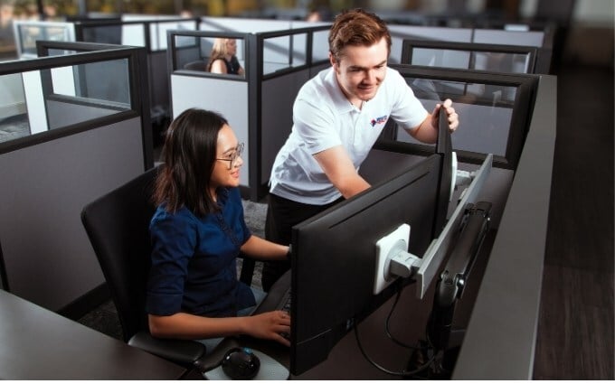 Ergonomist adjusts office employees monitor height