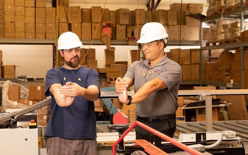 Industrial sports medicine professional shows employee discomfort prevention stretches