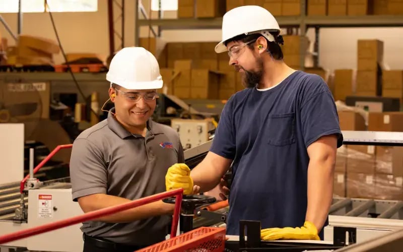 Industrial sports medicine professional works with employee on proper body mechanics