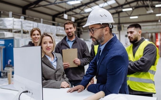 Manager presenting safety information to team of warehouse employees
