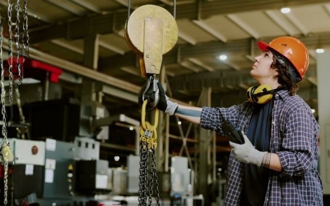 Manufacturing employee adjusts lift equipment