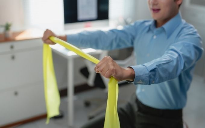 Office employee using resistance band at work