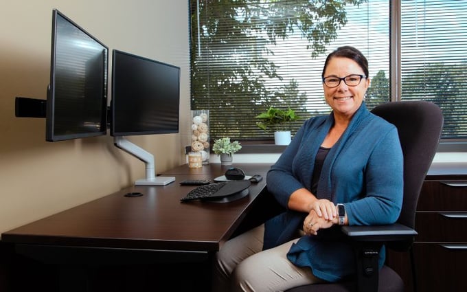 Office worker smiling from her ergonomically set up desk