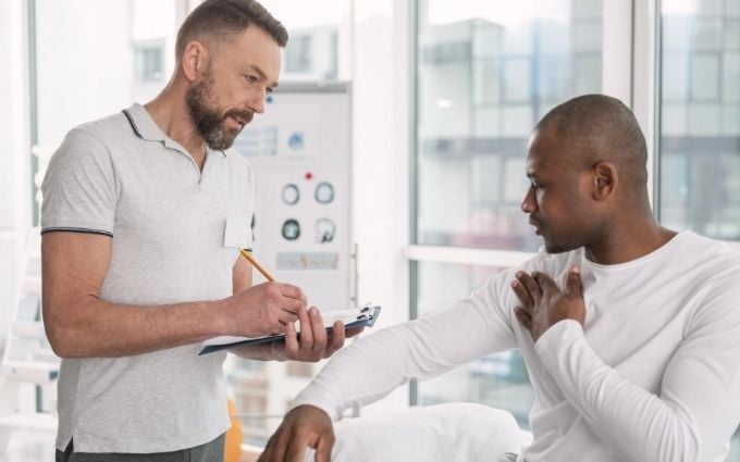 Onsite health provider examining worker with shoulder discomfort