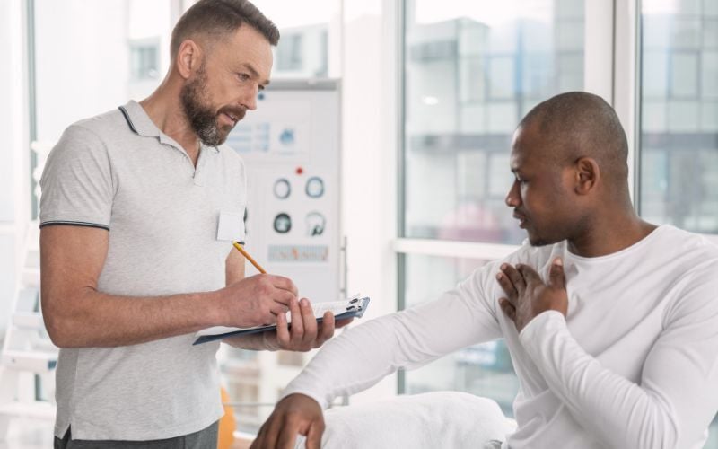 Onsite health provider talks with employee experiencing shoulder discomfort