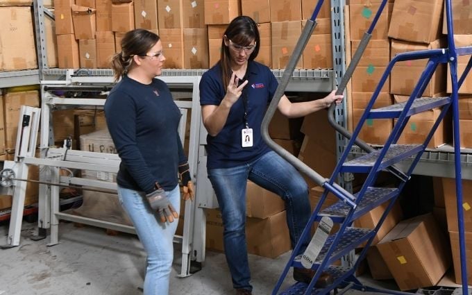Onsite injury prevention specialist shows employee how to use ladder safely