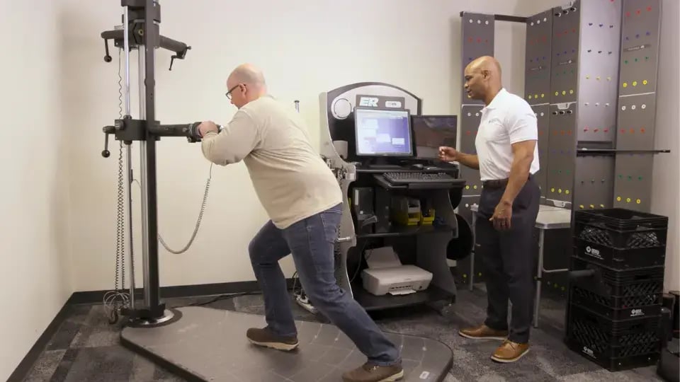 Man in an employment testing clinic using his whole body to push test machine
