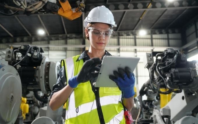 Safety Manager in a manufacturing facility reviews information on a tablet