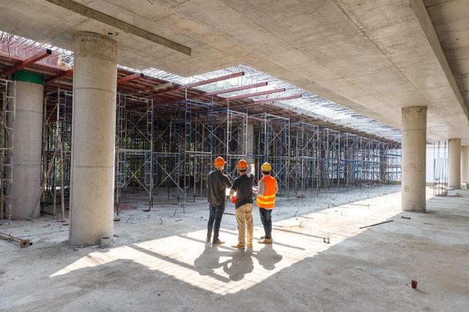 Three men appraising a construction site