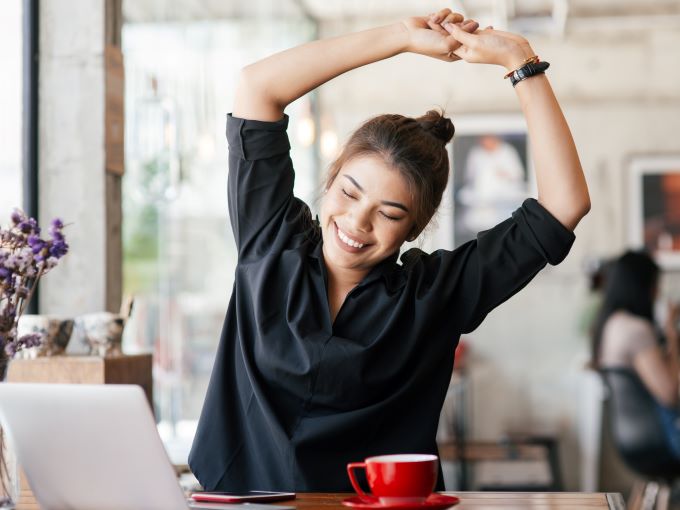 woman doing stretches while sitting at computer desk
