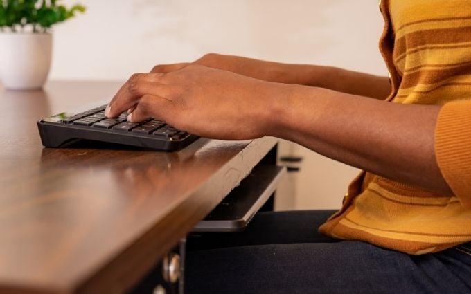 Woman typing on a keyboard with good ergonomic typing position