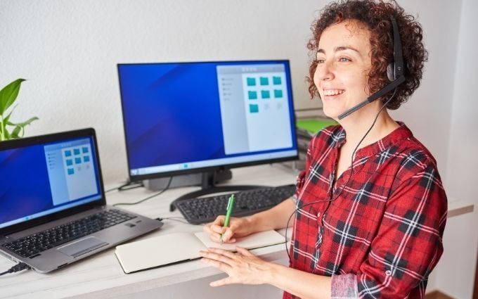 Woman working at a  standing desk wearing an ergonomic headset