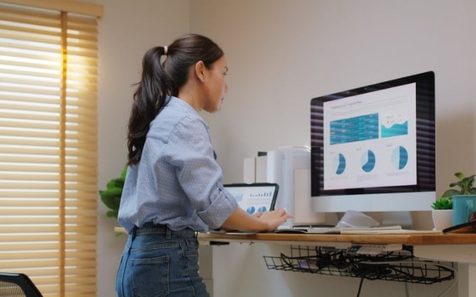 Woman working at a standing desk in her home office