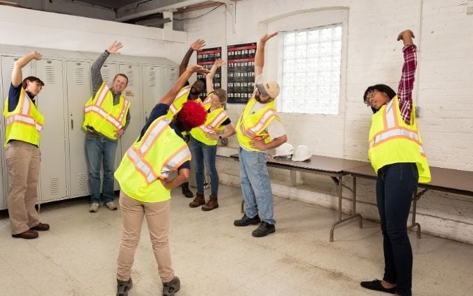 Workers stretching together during a pre-shift warm up