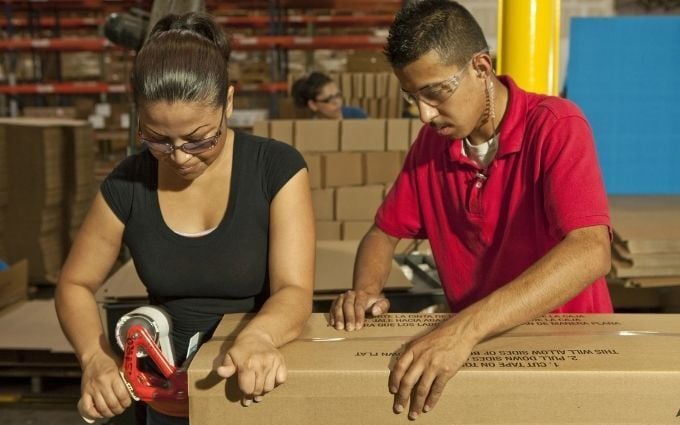 Workers taping a box