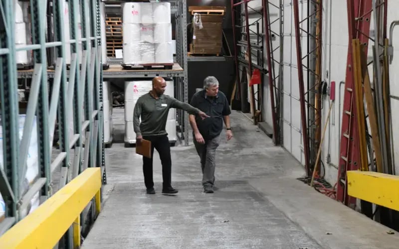 Two men walk through a workplace performing a safety inspection