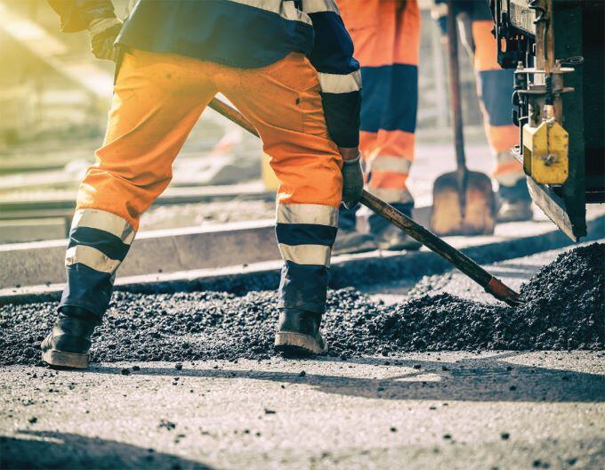 a worker shoveling gravel