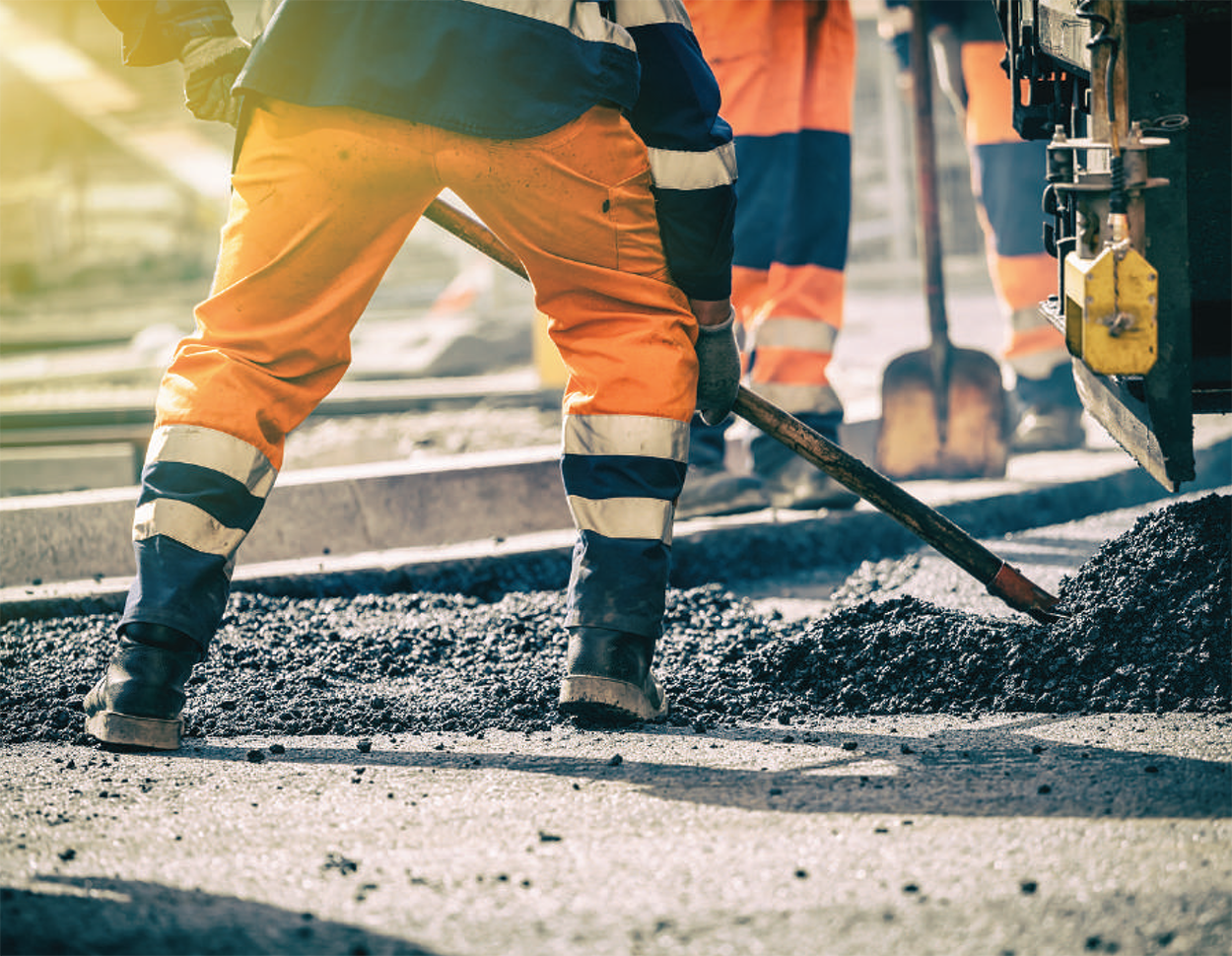 a worker shoveling gravel 