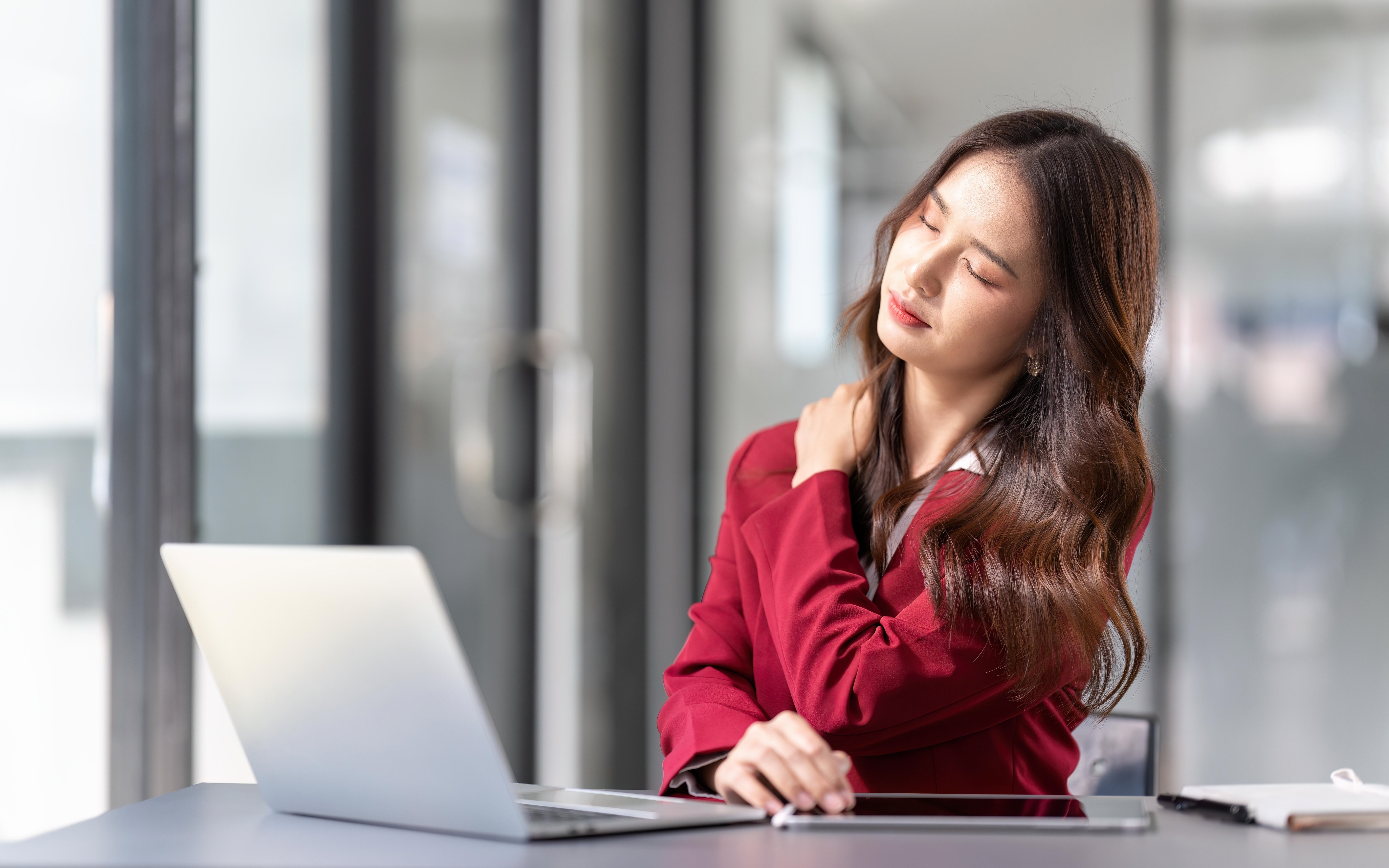 woman massaging her shoulder due to discomfort